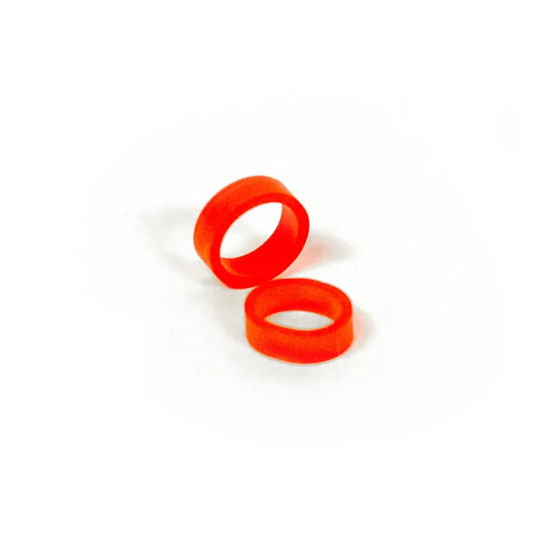 Two red Band of REBELS elastic silicone bands on white background, close-up view.