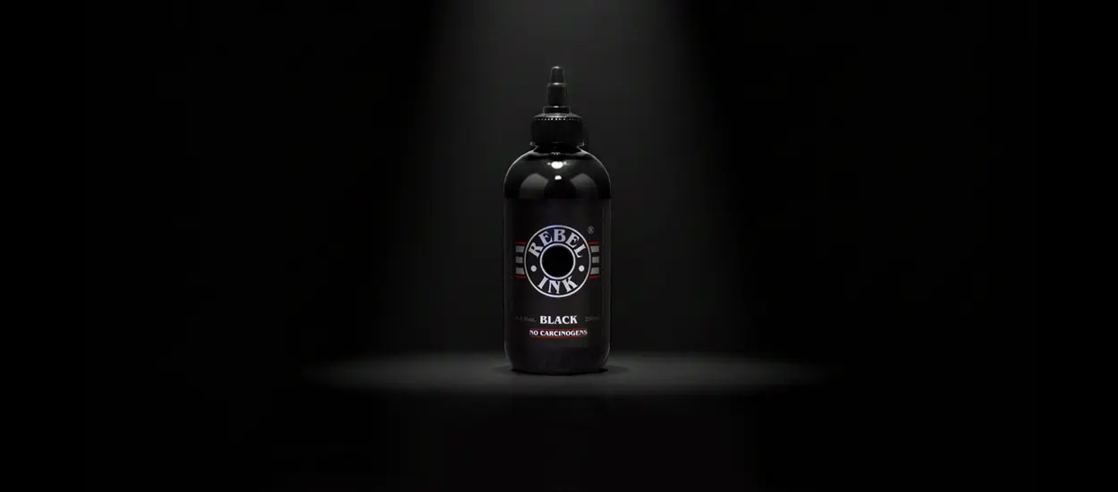 High-load carbon REBEL Black professional tattoo ink bottle in a studio spotlight.