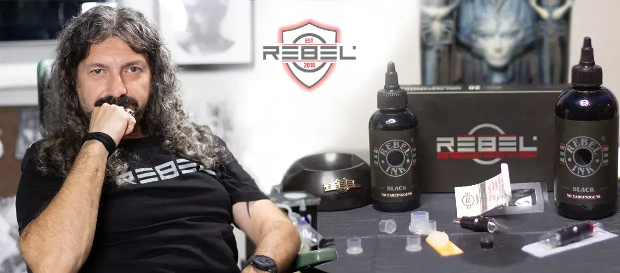 Caesar The Hun, founder of REBEL Tattoo Equipment, in studio with REBEL tattoo ink and professional tools