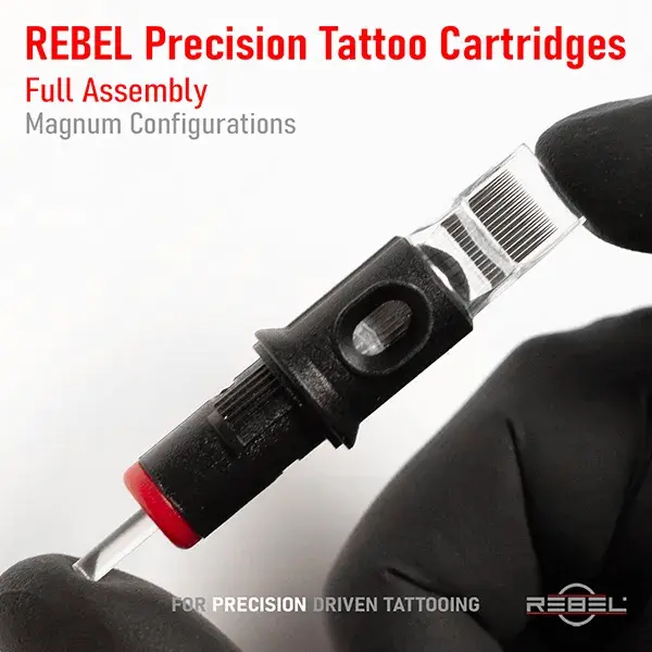 REBEL Precision Tattoo Cartridge full assembly magnum – gloved hand, black housing, red cap, clear tip, needle group visible