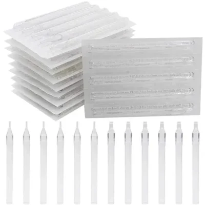 Vintage disposable plastic tattoo tubes — individually wrapped sterile packs stacked alongside unwrapped round liner tips in a row