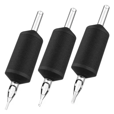Three vintage disposable plastic tattoo tubes with black rubber grips — round liner and flat shader tips with clear needle bars