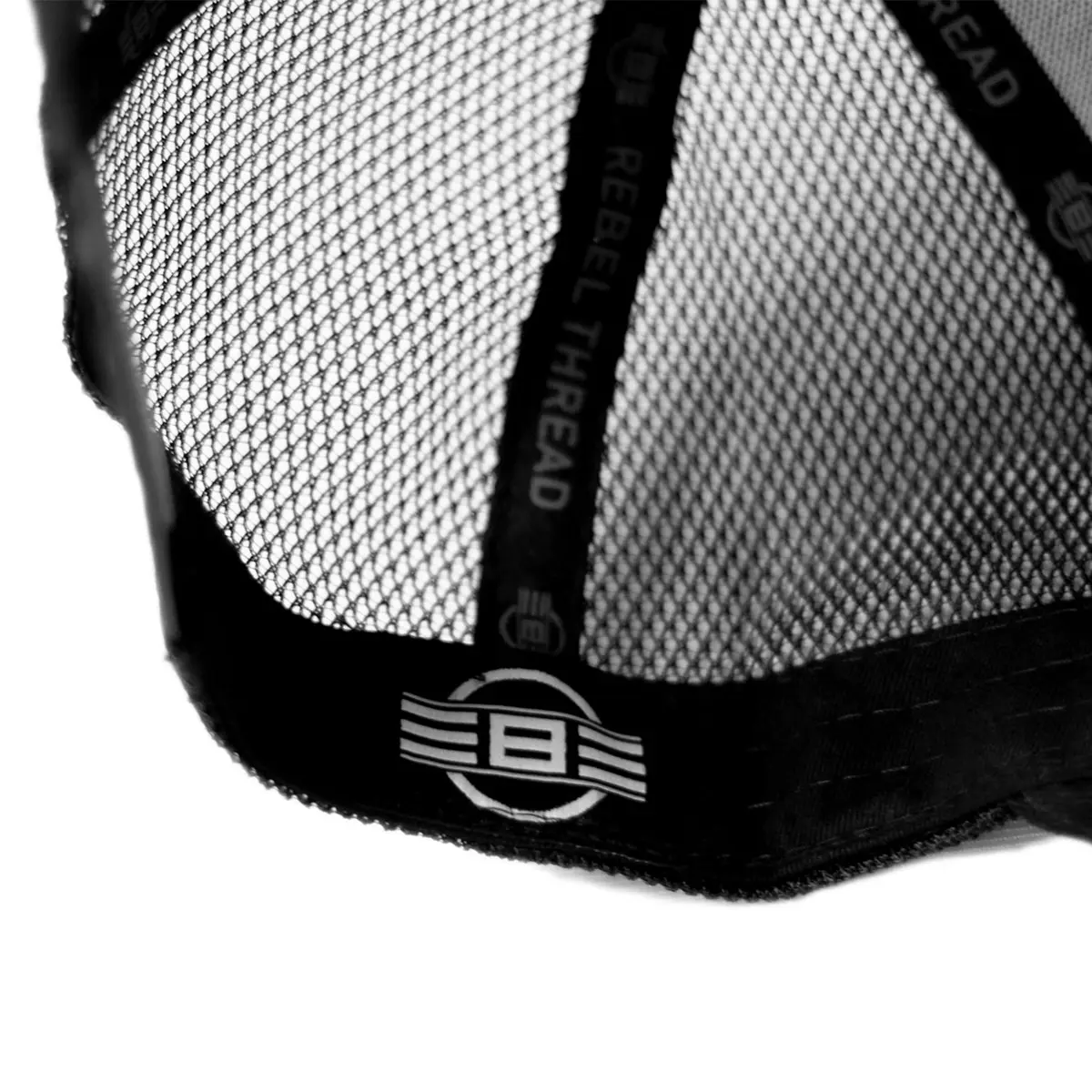 Close-up of REBEL Phantom Trucker Hat interior sweatband showing REBEL THREAD printed tape and satin REBEL brand tag